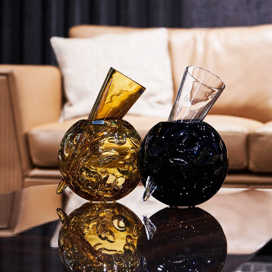 Mario Cioni Crystal Vulcano Amber Vase by Tondo Doni with other Black Vulcano Vase on a center table in modern living room available at spacio india for luxury home decor collection of decorative vases.