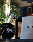 Mario Cioni Crystal Vulcano Black Vase by Tondo Doni with books in a modern shelf available at Spacio India for luxury home decor collection of decorative vases.