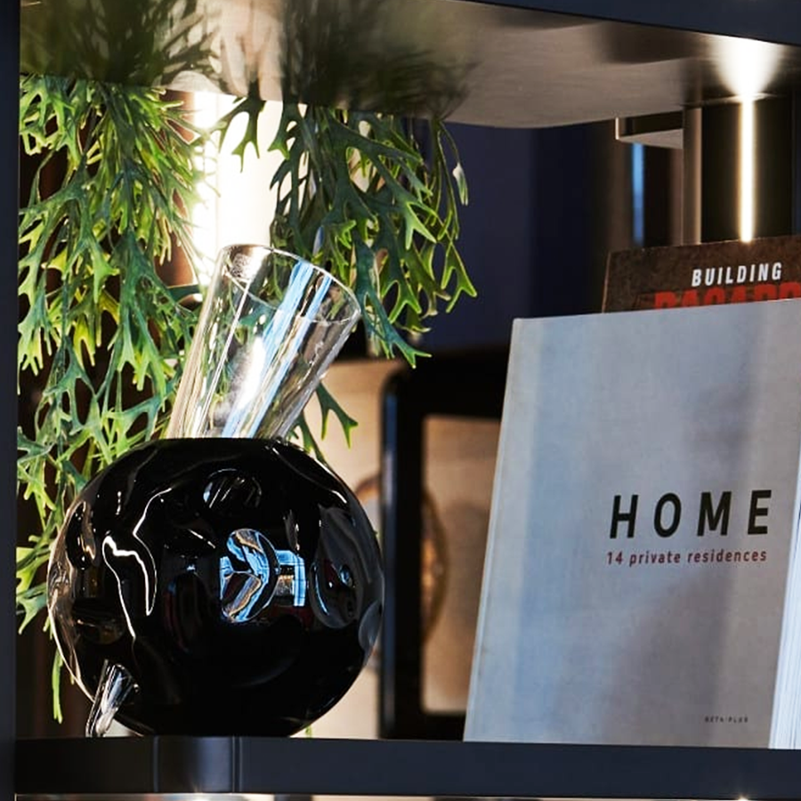 Mario Cioni Crystal Vulcano Black Vase by Tondo Doni with books in a modern shelf available at Spacio India for luxury home decor collection of decorative vases.