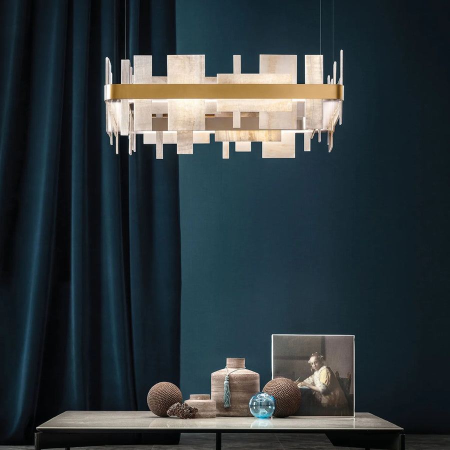 Modern chandelier hanging above a table with decorative items against a dark blue wall by Masiero available at Spacio retail stores in Mumbai & Kolkata. 