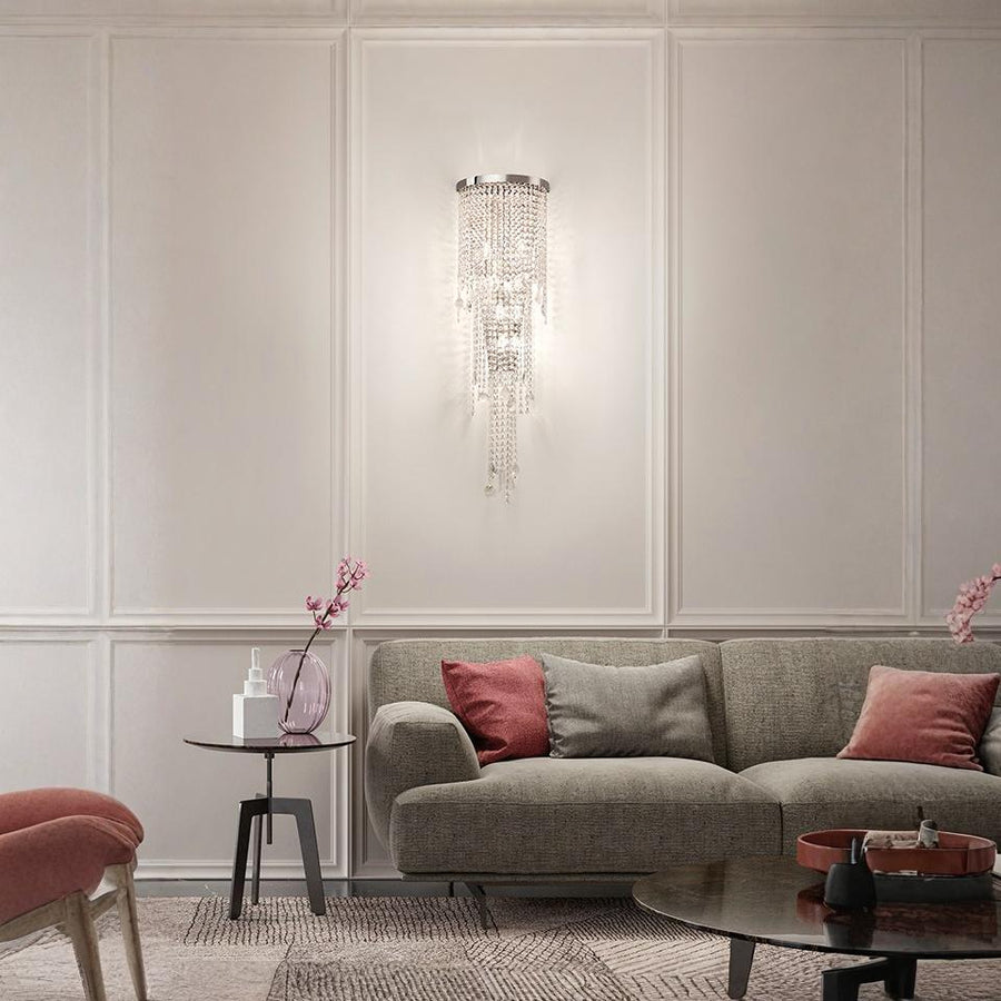 Living room with a gray sofa, red pillows, and a crystal wall light.