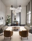 Modern living room with a chandelier, sofa, chairs, and decorative items.