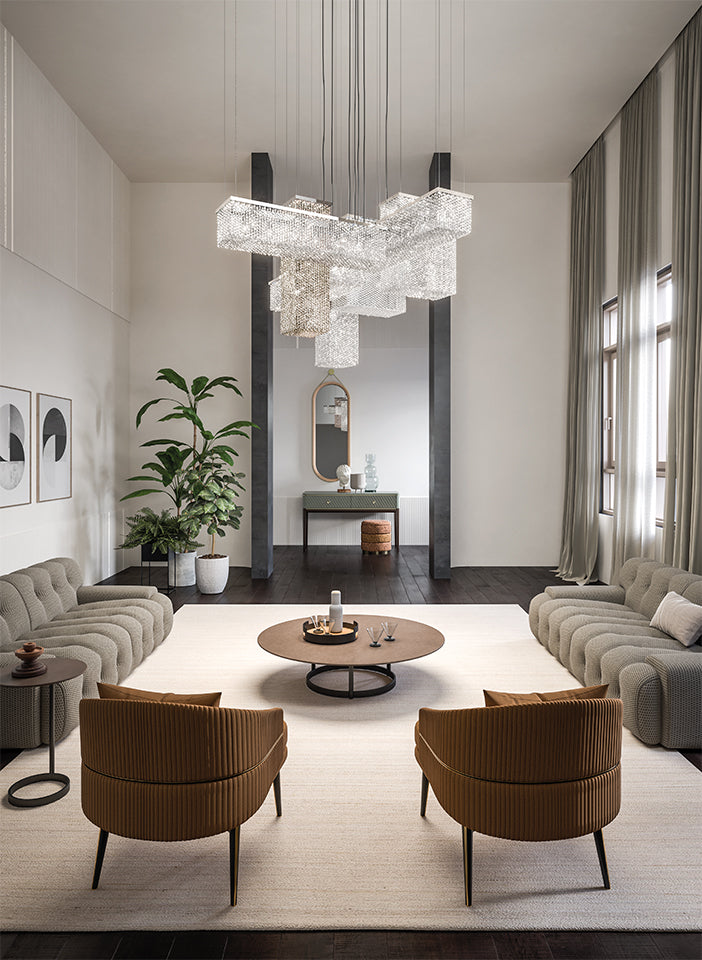 Modern living room with a chandelier, sofa, chairs, and decorative items.
