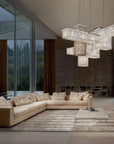 Modern living room with a chandelier, sofa, and bookshelf.