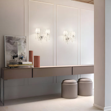 Modern interior with a long vanity table, stools, and wall-mounted lights crystal lights from Masiero, available at Spacio in India. 