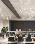 Modern conference room with round tables, chairs, and decorative ceiling lights.