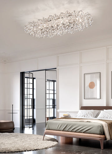 Modern bedroom with a crystal chandelier from Masiero, bed, and wall art.