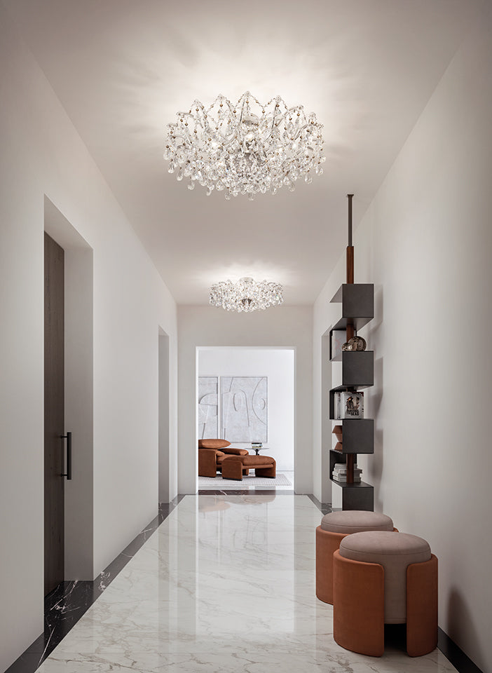 Modern hallway with chandelier, shelves, and stools