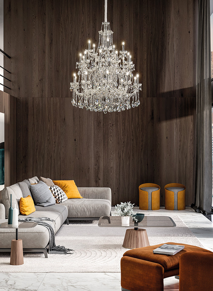 Modern living room with a chandelier, gray sofa, and orange ottoman.