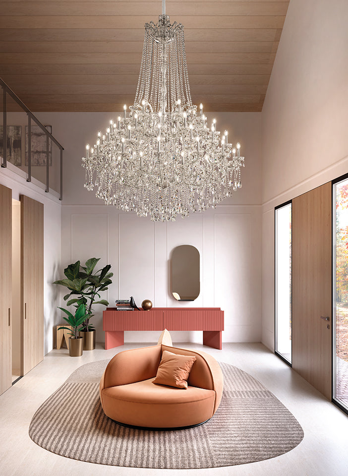 Modern interior with a chandelier, round orange chair, and pink console table.
