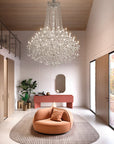 Modern interior with a chandelier, round orange chair, and pink console table.
