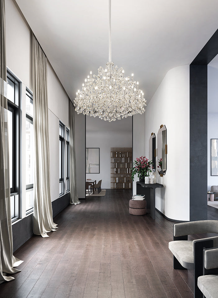 Modern interior with a chandelier, bookshelf, and seating area.