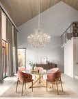 Modern dining room with a chandelier, round table, and pink chairs.