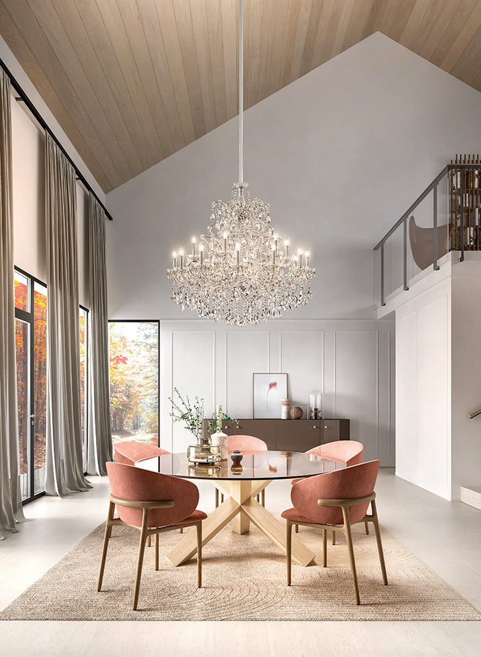 Modern dining room with a chandelier, round table, and pink chairs.