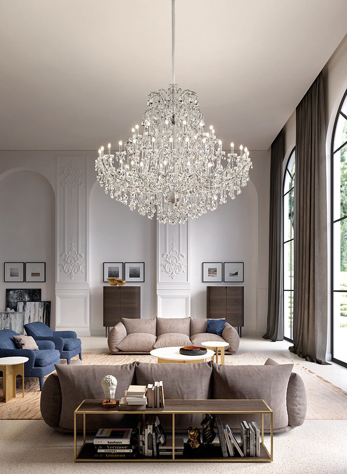 Luxurious living room with a large chandelier, gray sofa, and decorative items.