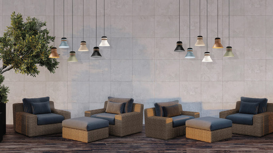 Outdoor furniture set with cushions against a tiled wall along with outdoor pendant lights from Masiero, available at Spacio. 