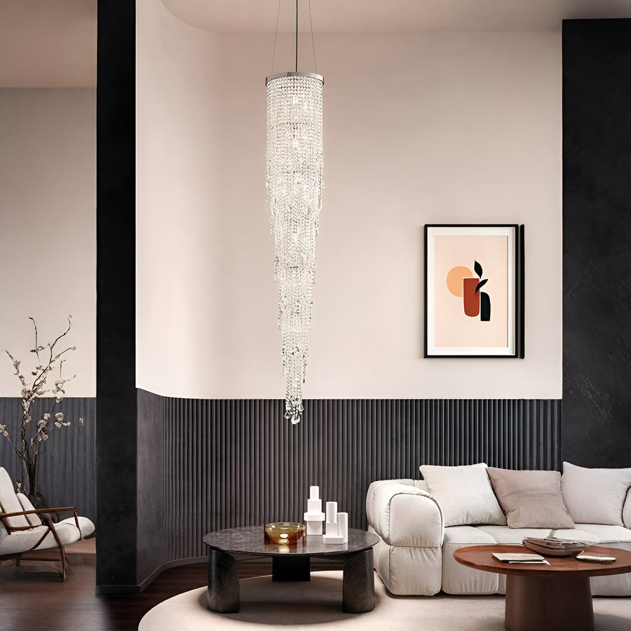 Modern living room with a crystal chandelier, sofa, and wall art.
