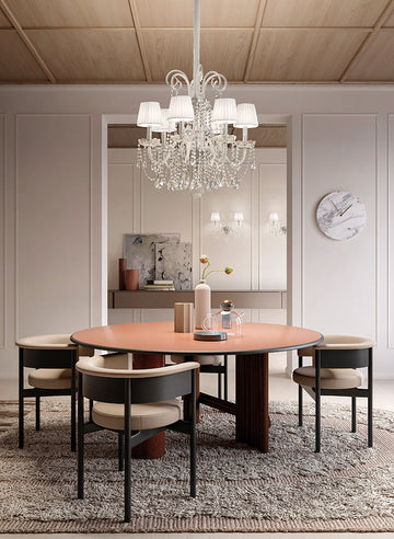 Dining room with a round table and chairs, featuring a crystal chandelier from Masiero. 