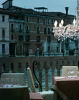 Masiero's Drylight chandelier hanging above a dining table in a restaurant by the canal in Venice. 
