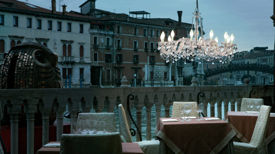 Masiero's Drylight chandelier hanging above a dining table in a restaurant by the canal in Venice. 