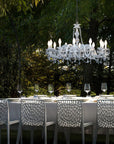 Dining table set with chairs and a chandelier in an outdoor setting