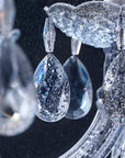 Close-up of a crystal chandelier with intricate details on a dark background