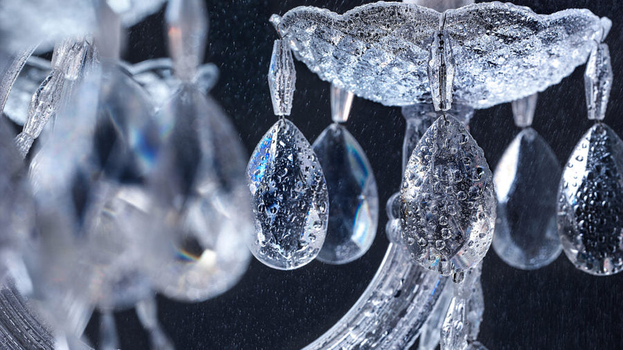 Close-up of a crystal chandelier with intricate details on a dark background