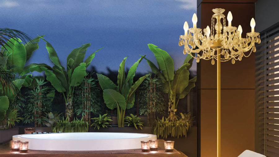 Luxurious outdoor setting with a chandelier, bathtub, and outdoor chandelier style floor lamp against a night sky.