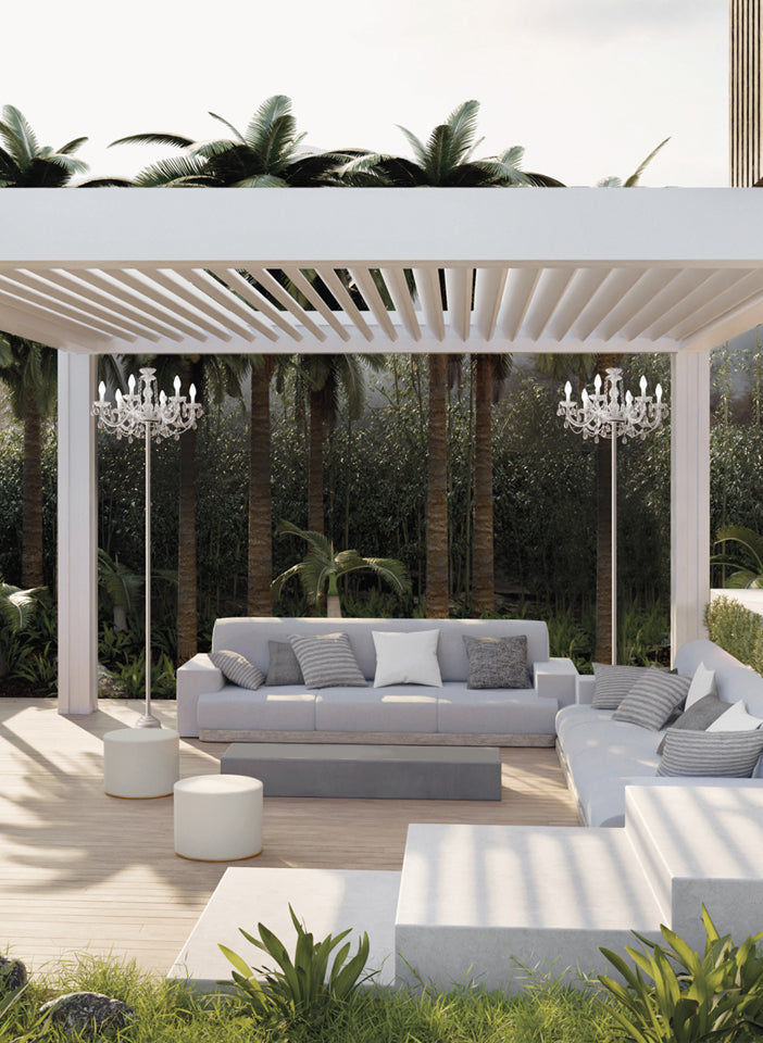 Modern outdoor patio with white pergola, sofa, and chandeliers style floor lamp.