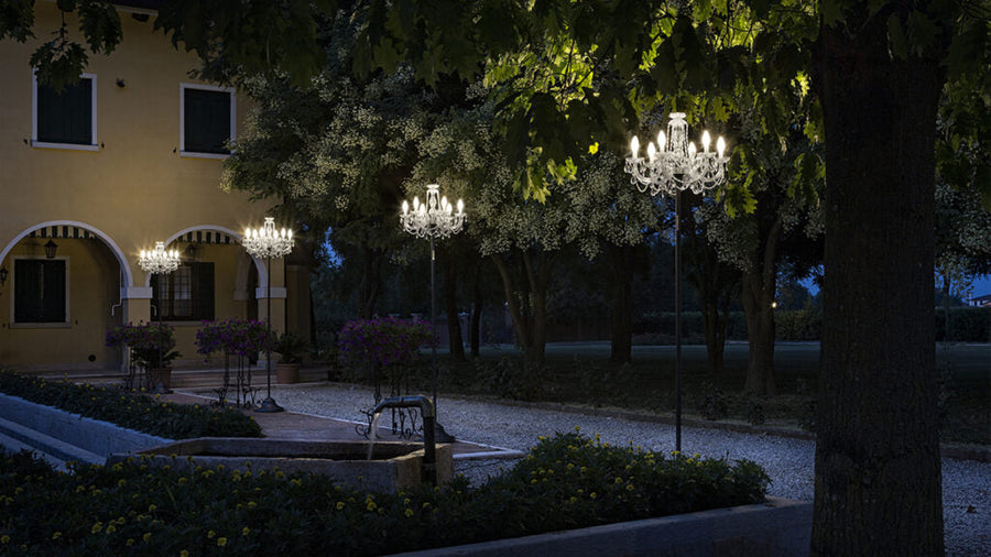Decorative outdoor chandeliers on a building exterior at night