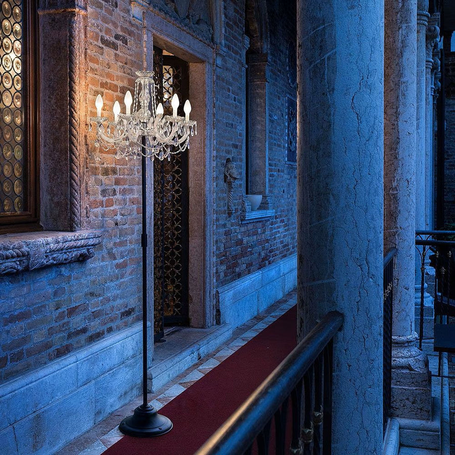 Chandelier floor lamp from Masiero in a dimly lit room with brick walls.