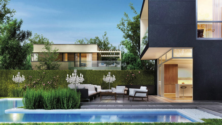 Modern house exterior with pool, garden, and outdoor furniture and table outdoor chandeliers. 