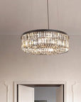 Chandelier hanging from the ceiling in a room with white walls and a door.