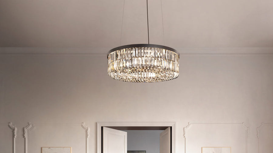 Chandelier hanging from the ceiling in a room with white walls and a door.