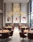 Modern restaurant interior with a grand Raqam chandelier from Masiero, tables, and chairs.