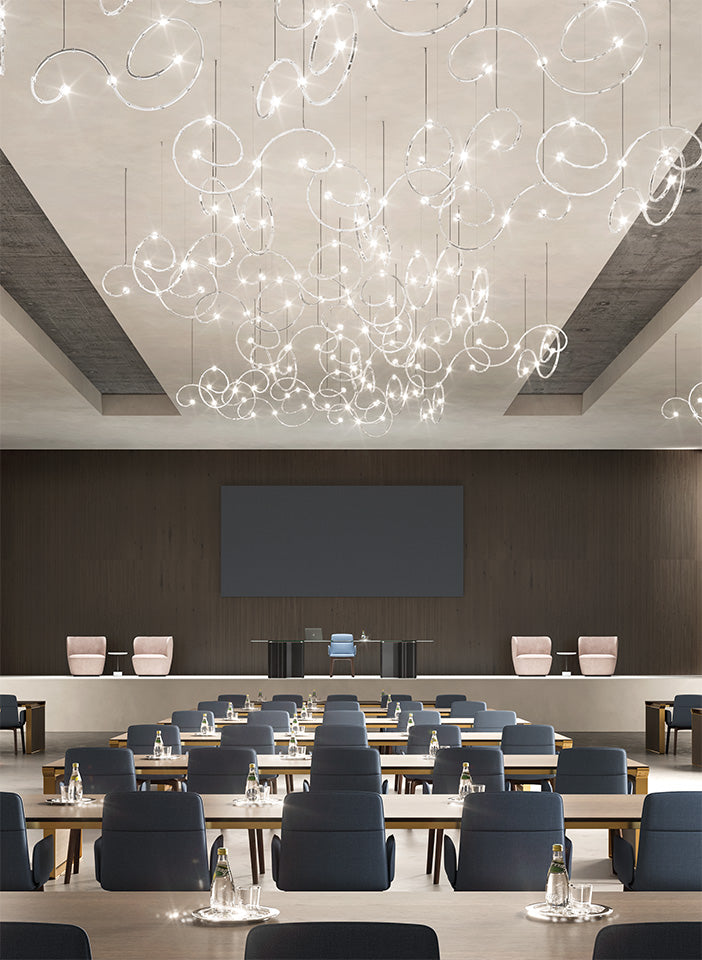 Modern conference room with ceiling lights and tables arranged for meetings.