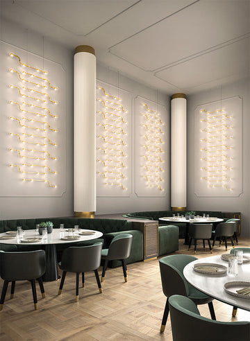 Modern restaurant interior with round tables, chairs, and decorative modular light fittings from Masiero