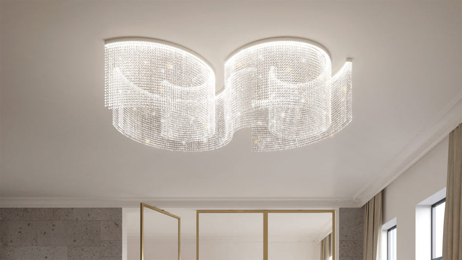 Modern chandelier hanging from a ceiling in a room with neutral walls and a window.