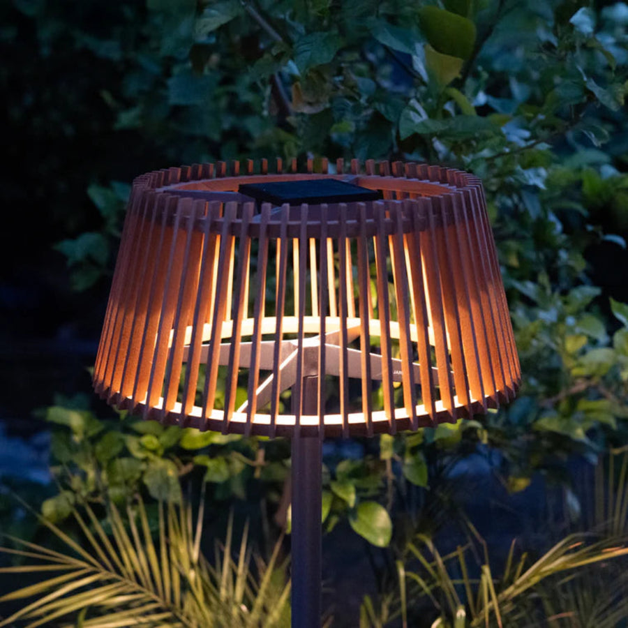 Solar teak floor lamp with wooden design in a garden setting by Les Jardins available at Spacio retail stores in Mumbai & Kolkata. 