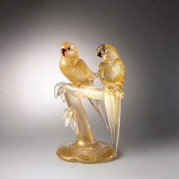 Murano Glass sculpture of two parrots on a branch against a gray background