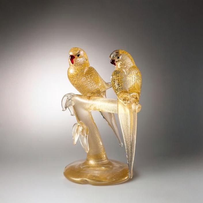 Murano Glass sculpture of two parrots on a branch against a gray background