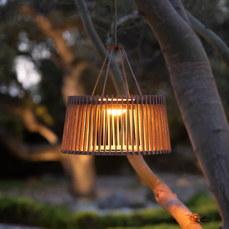 Wooden pendant light hanging outdoors with trees in the background by Les Jardins available at Spacio retail stores in Mumbai & Kolkata. 