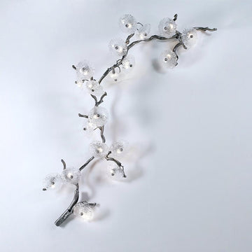 Decorative wall light fixture shaped like a branch with lights on a white background