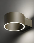 Modern wall-mounted light fixture with a metallic finish on a dark background