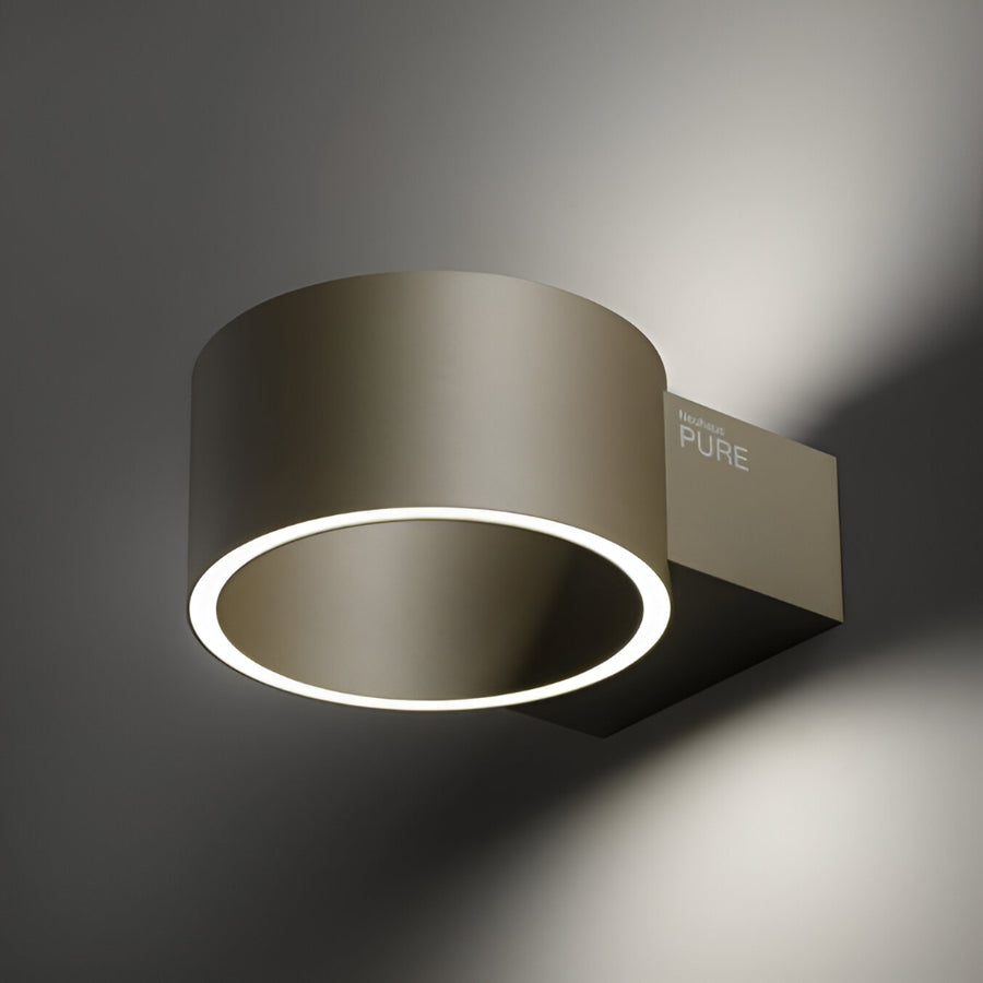 Modern wall-mounted light fixture with a metallic finish on a dark background