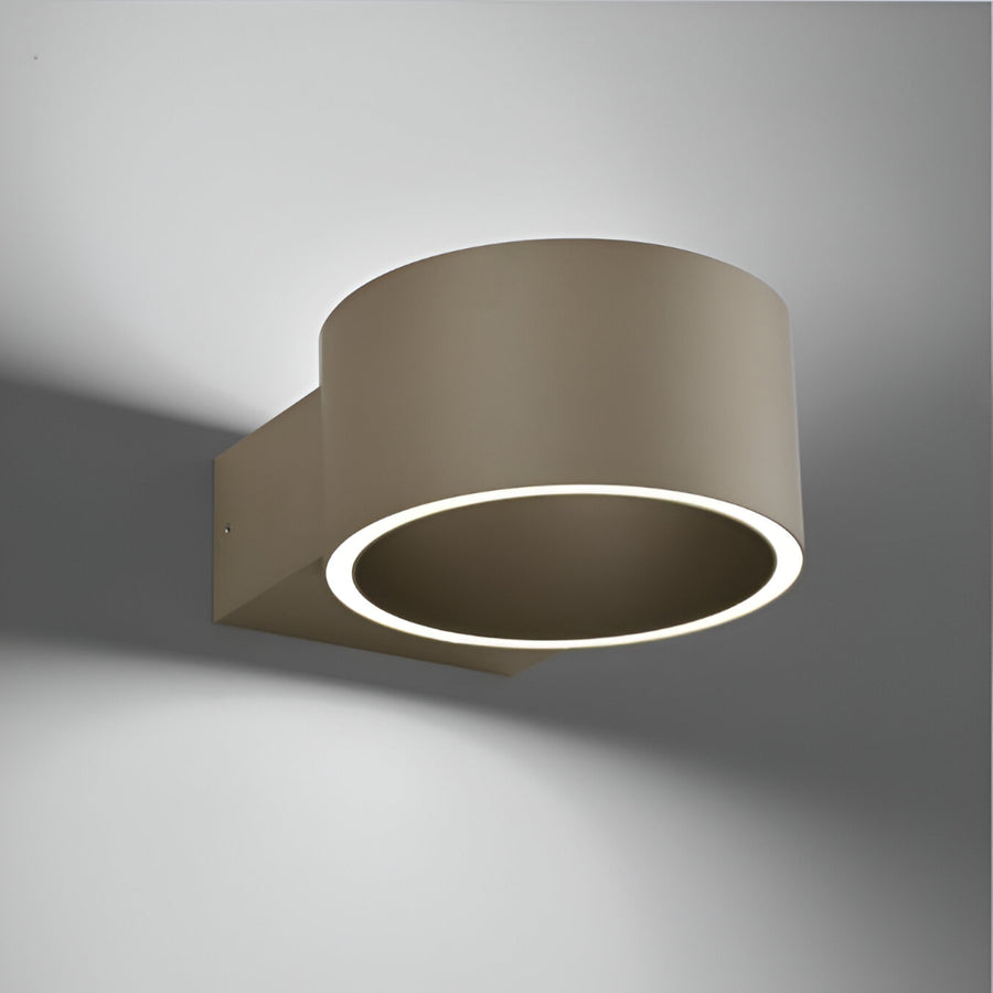 Modern wall-mounted light fixture with a circular design on a gray background