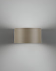Beige cylindrical wall light fixture on a gray background