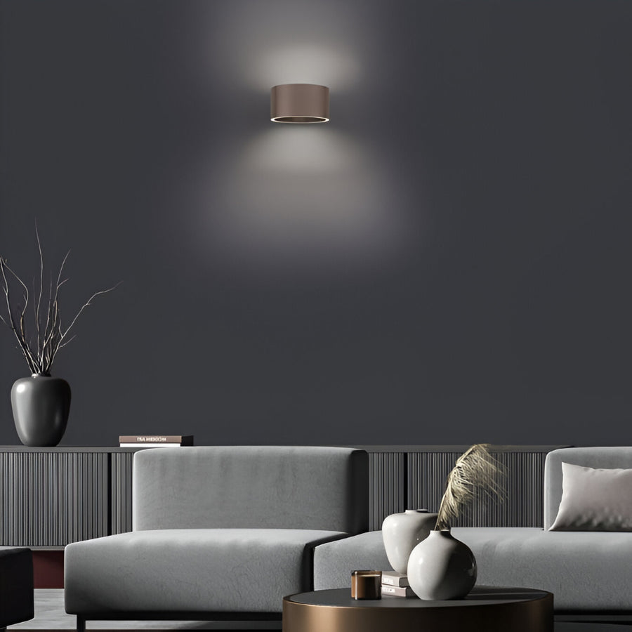 Modern living room with a gray sofa, dark wall, and decorative elements.