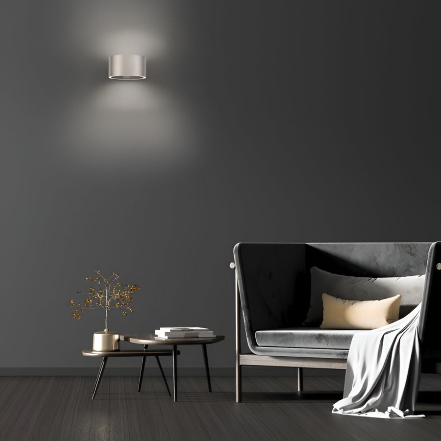 Modern living room with a dark gray wall, a sofa, a coffee table, and a wall-mounted light fixture.