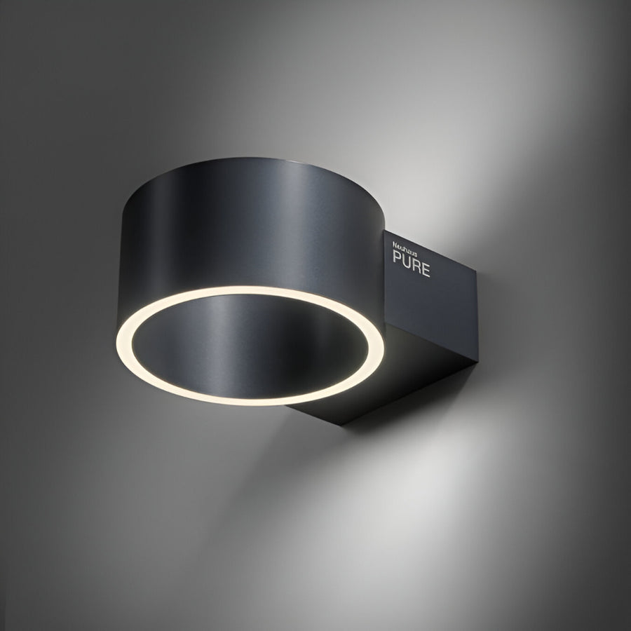 Modern black wall rechargeable light fixture with a ring of light on a dark background